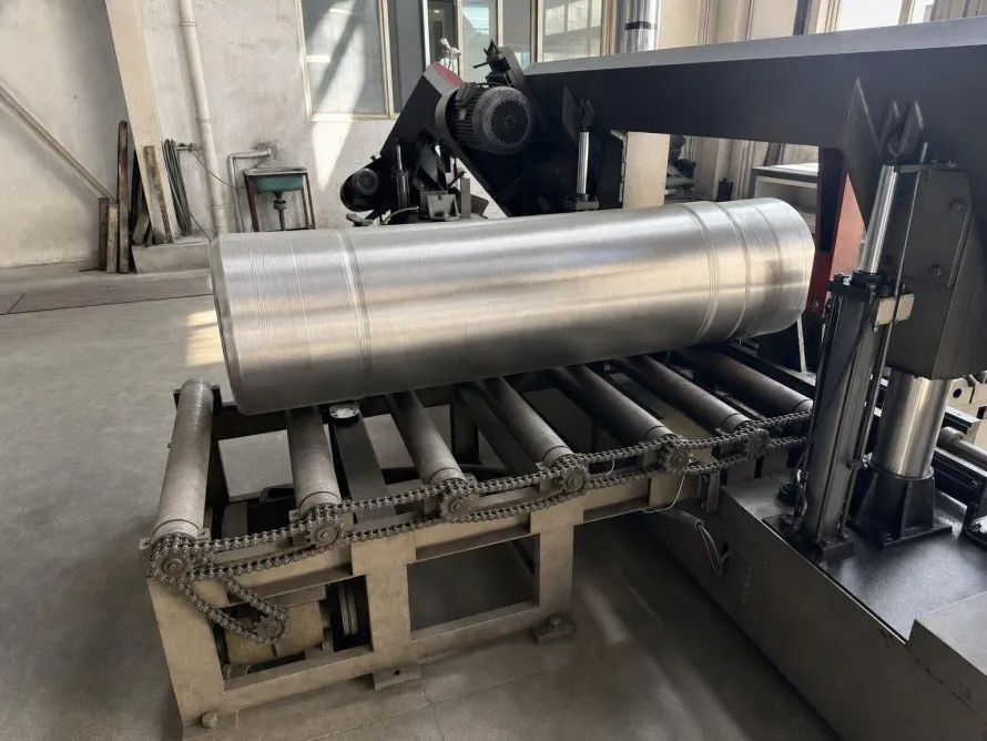 Long machined titanium billet on a workshop roller feed beside a bandsaw
