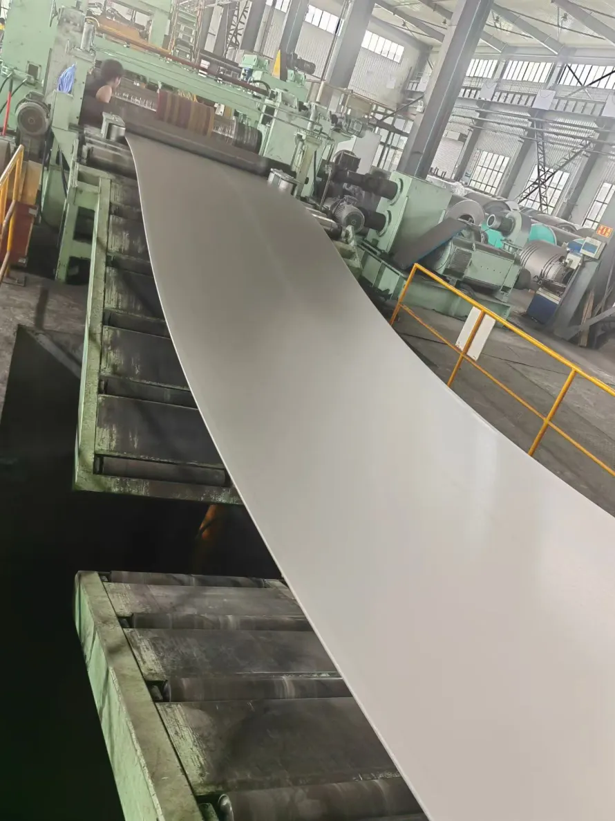 A user-supplied titanium sheet moving through a mill line illustrates real product-form processing; it is not a specimen from the cited impact study.