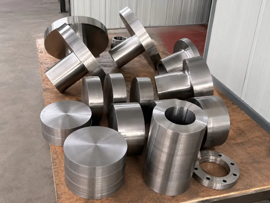 Machined cylindrical, ring and flange-shaped metal parts on a workshop table