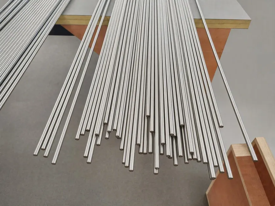 Polished titanium rods arranged in parallel groups on a workshop bench
