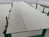 Reihen polierter runder Metallstäbe auf Werkstattgestellen