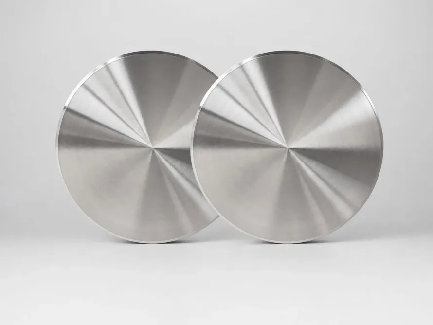Two overlapping machined metal discs with circular turning marks