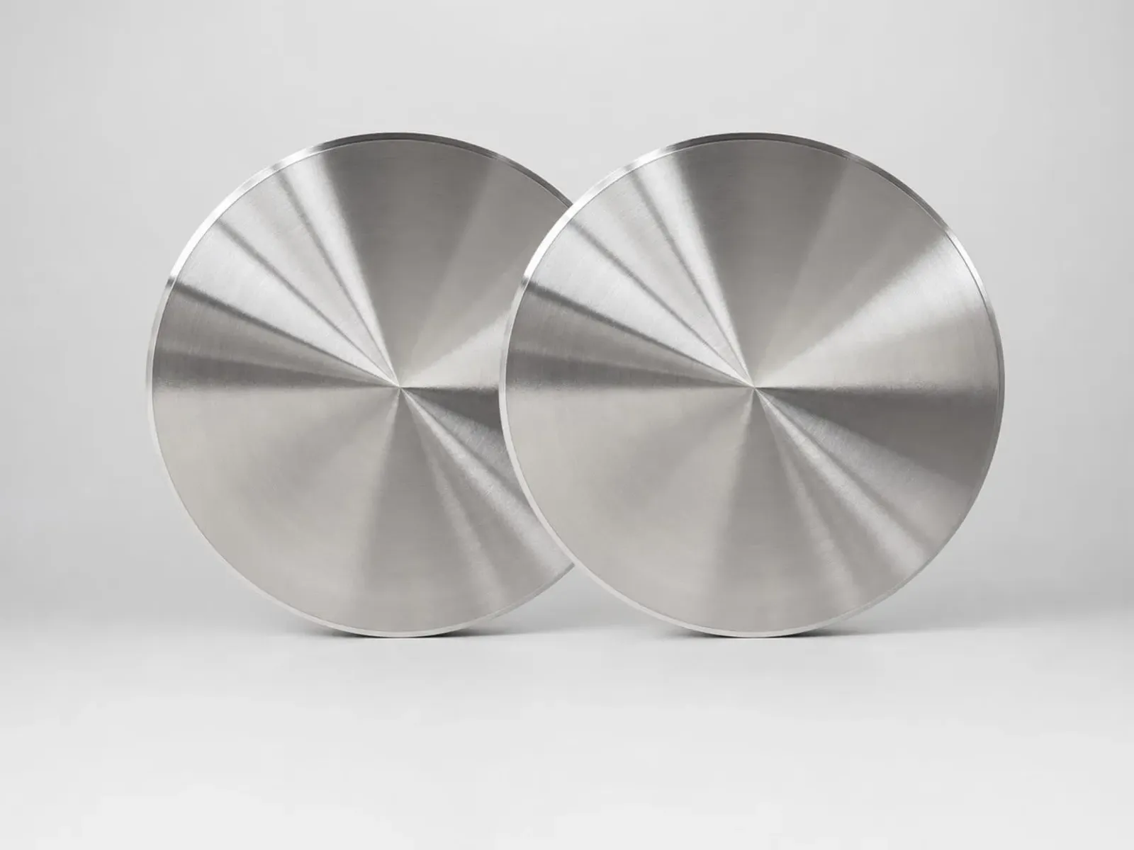 Two overlapping machined metal discs with circular turning marks