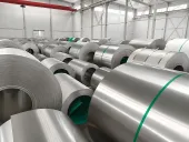 Titan-Blechcoils in einem Lager, die zeigen, warum strategische Mineralversorgung weiter mit Produktform, Zuteilung und Freigabenachweisen verbunden werden muss.