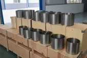 Titanium cylindrical parts staged on export crates, illustrating why AM buyers need batch identity and release data before acceptance.