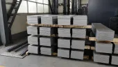 Stacked titanium plates in a workshop, illustrating why aerospace-linked buyers need product-form capacity reserved before release dates are trusted.
