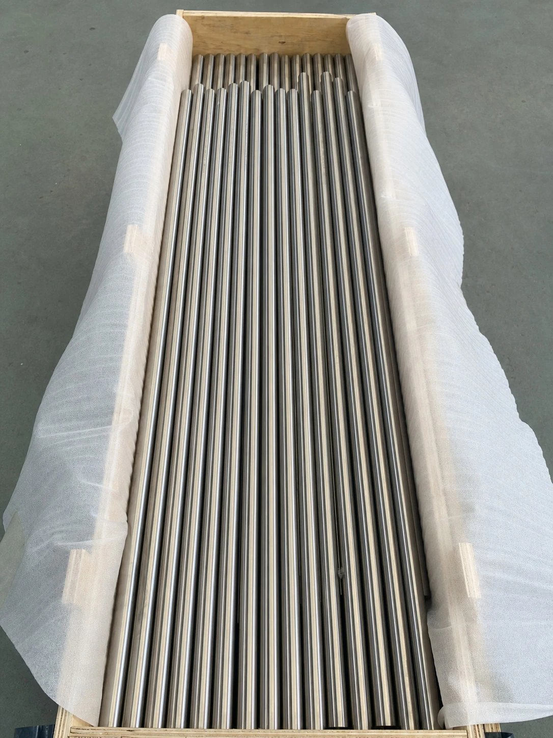 Crated titanium bars prepared for shipment, showing that visible stock still needs reserved inspection, packaging and release capacity.