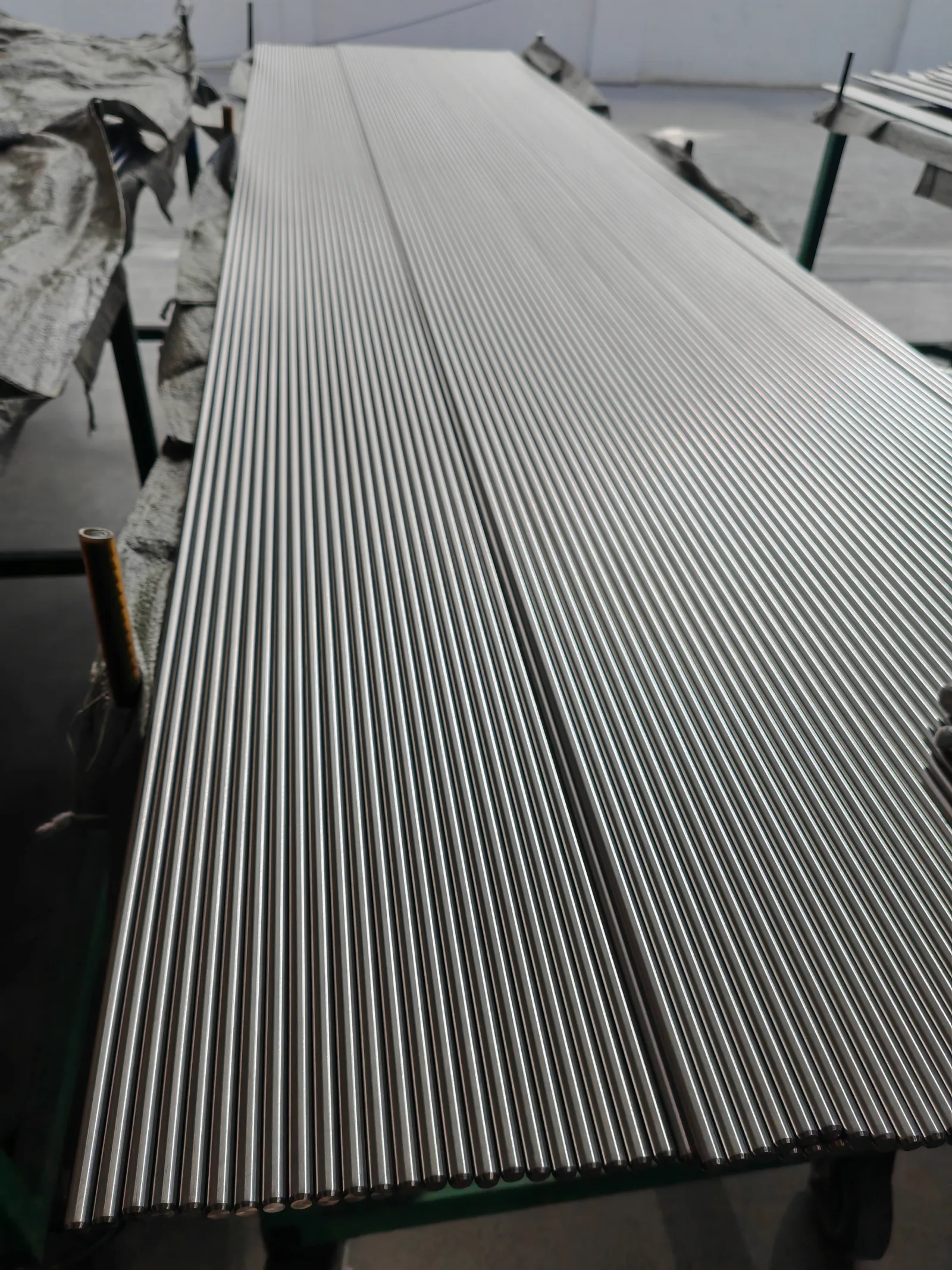 User-supplied bright titanium rods show a controlled surface condition; they provide industrial context and are not specimens from the cited AM electropolishing review.