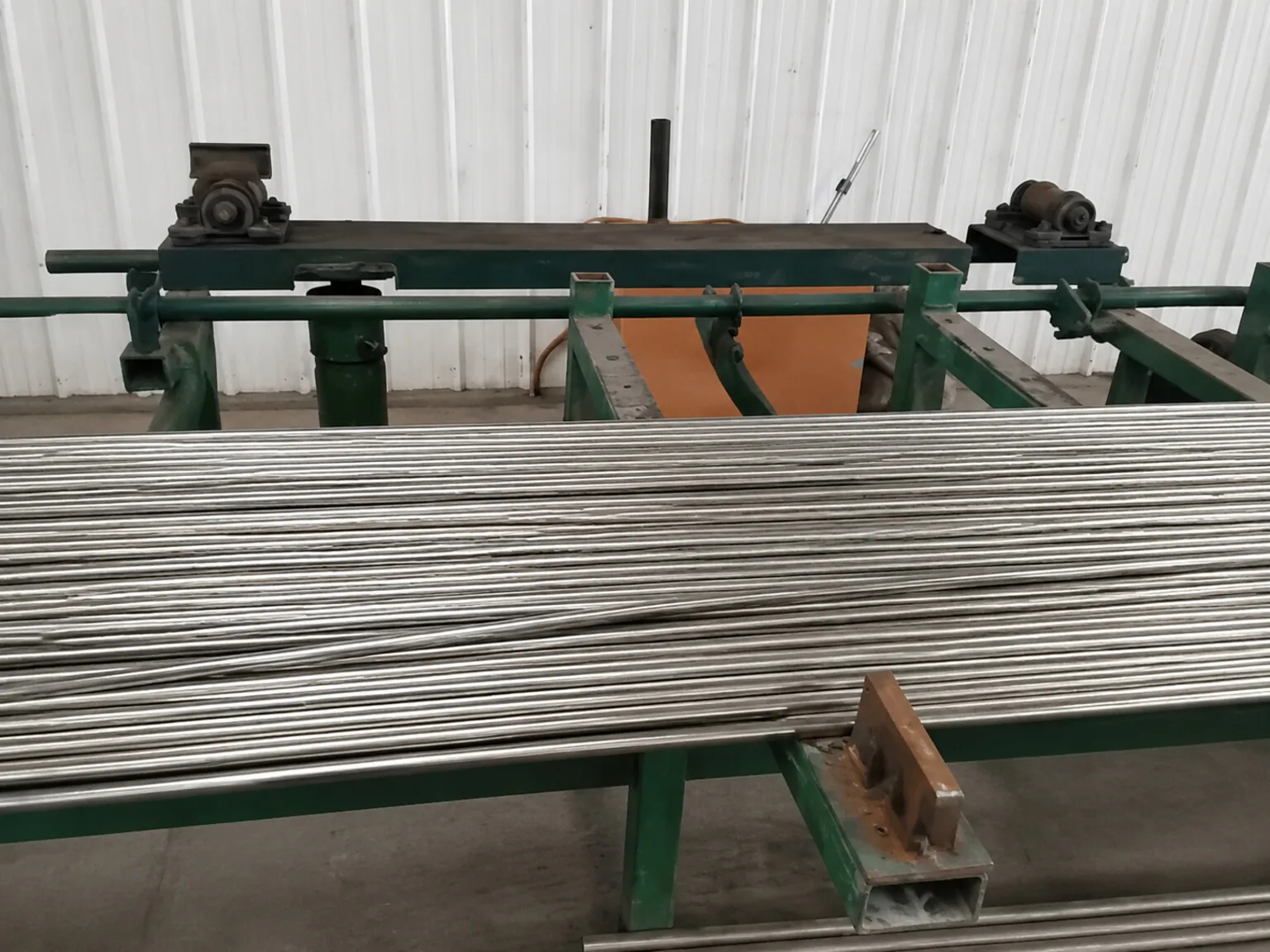 User-supplied titanium rod stock on a mill table illustrates product-form and route control; it is not Ti-O-Fe test material or Charpy evidence.