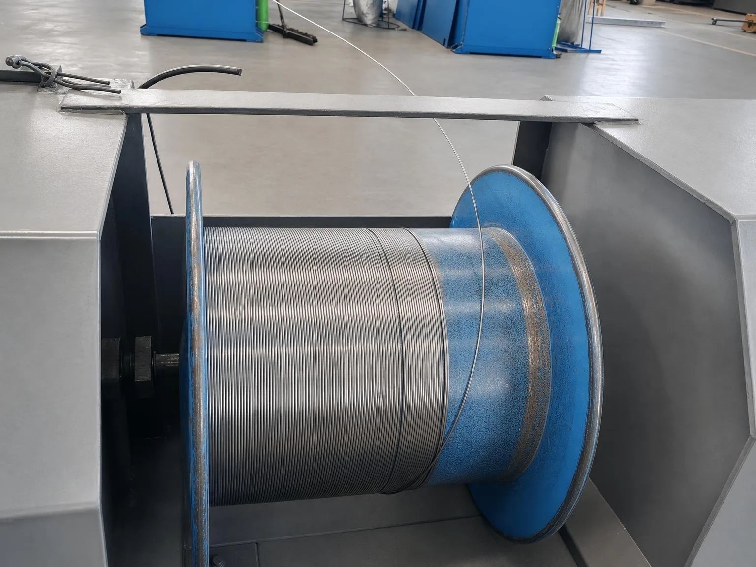 Titandraht auf einer industriellen Spule mit sichtbarem Zufuhrstrang