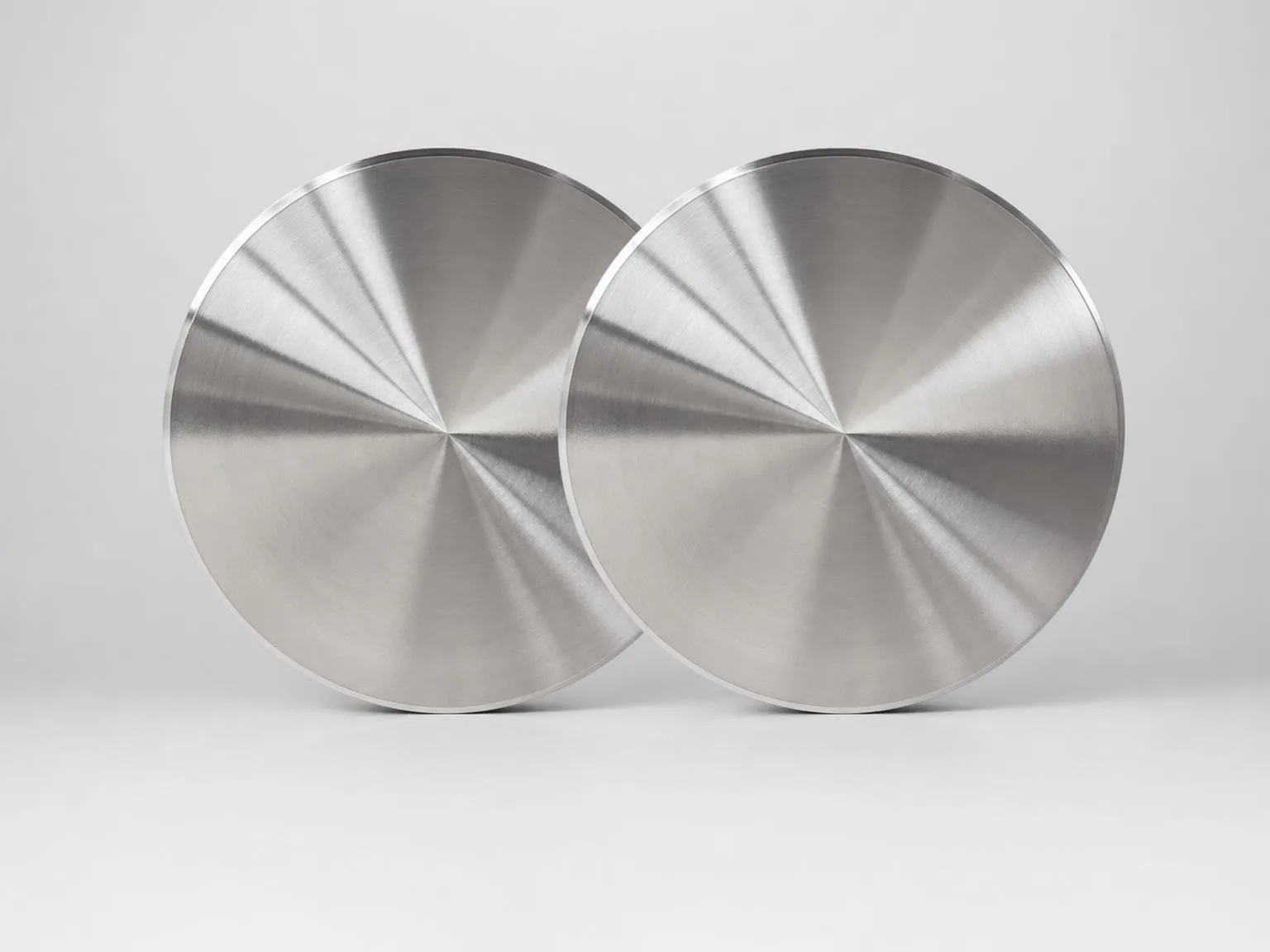 User-owned machined titanium discs illustrate a finished commercial form whose alloy, processing route and test evidence would need to be specified separately; they are not study specimens.