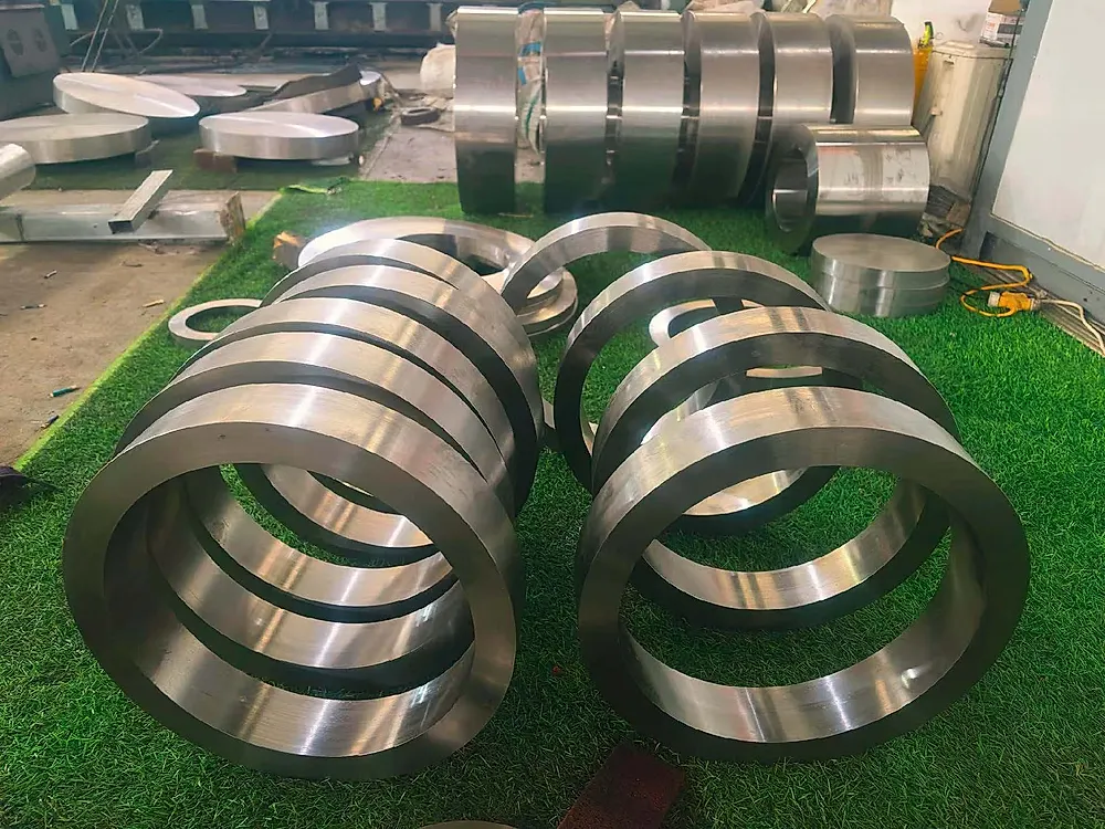 Multiple large titanium ring forgings laid out for inspection, common aerospace and chemical specifications