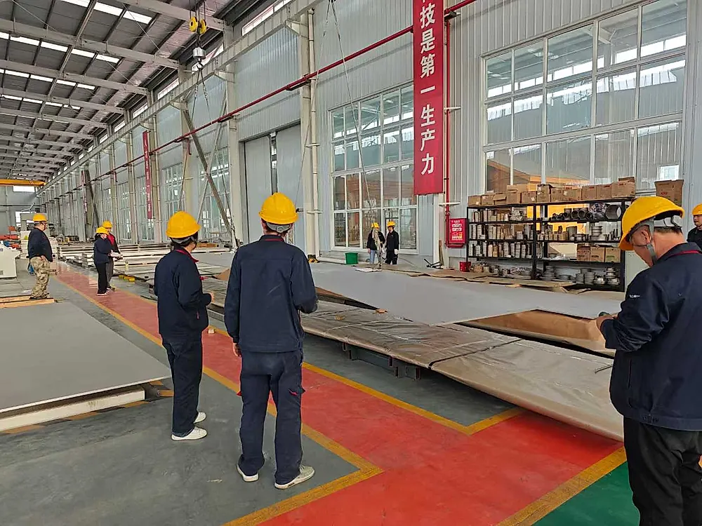 Workers handling large titanium plates with overhead crane in Baoji workshop