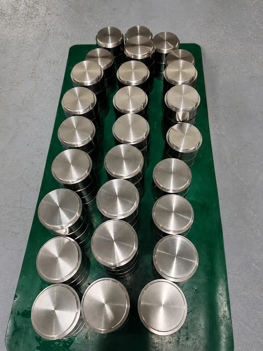 User-owned machined titanium discs illustrate repeatable finished-part supply; they are not components from the reported device.
