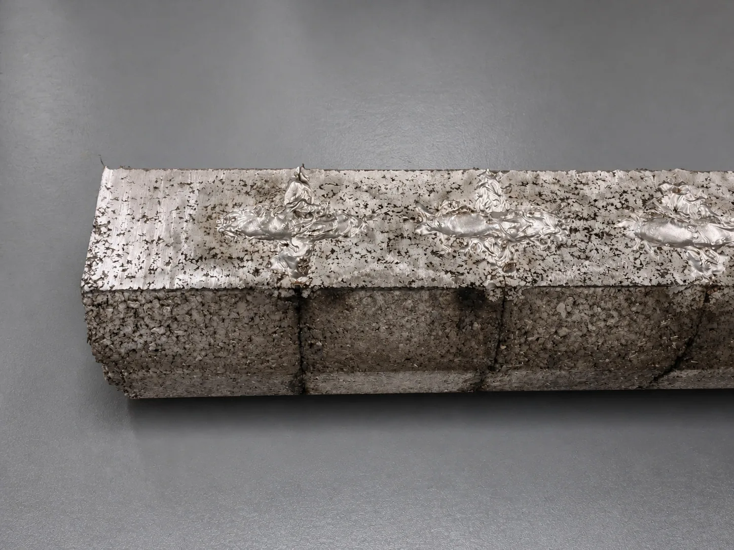 A user-supplied rough titanium material compact illustrates feedstock-state control; it is not Ti-Cu powder or a specimen from the cited study.