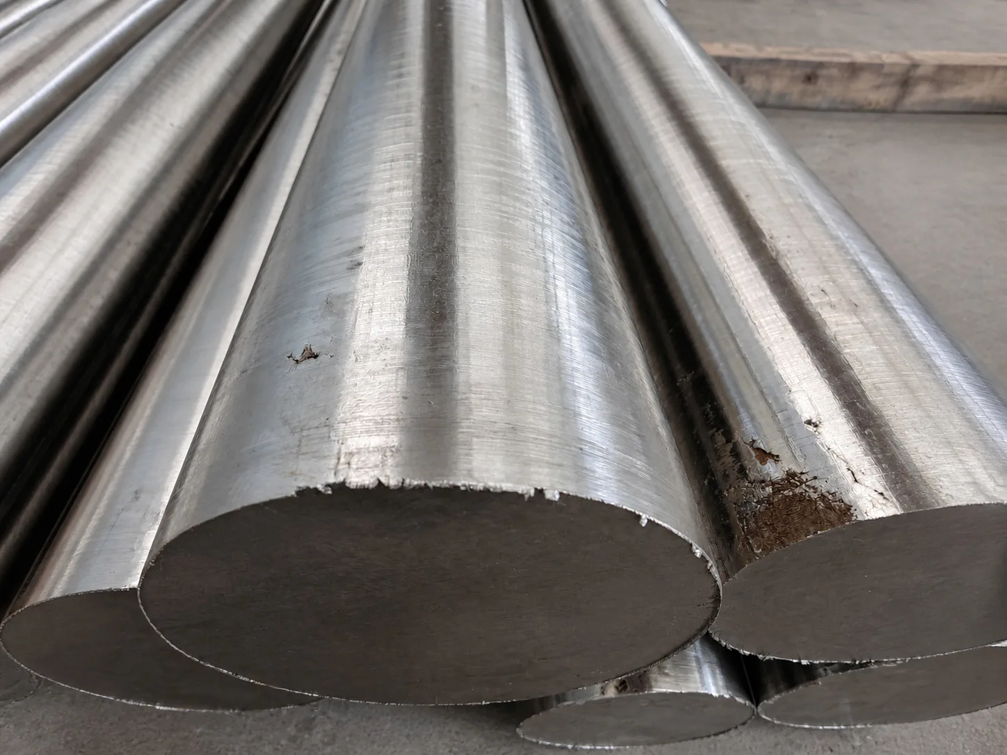 Close view of stacked cylindrical metal billets with rough cut faces