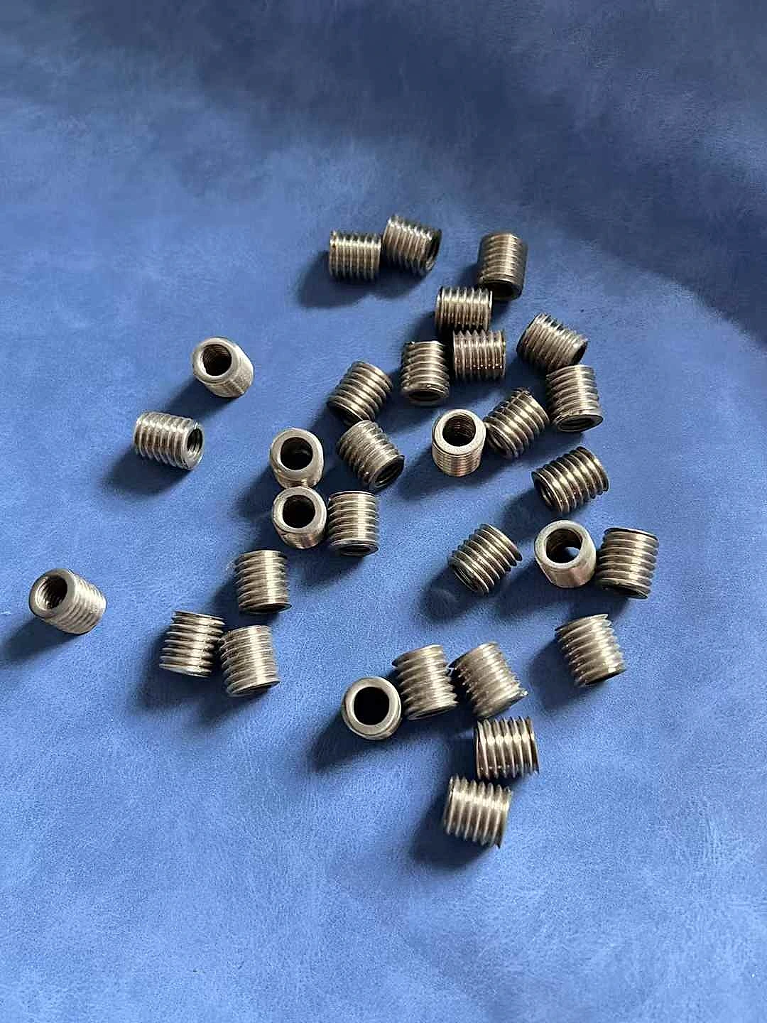 Titanium threaded inserts for foldable phone hinge assembly