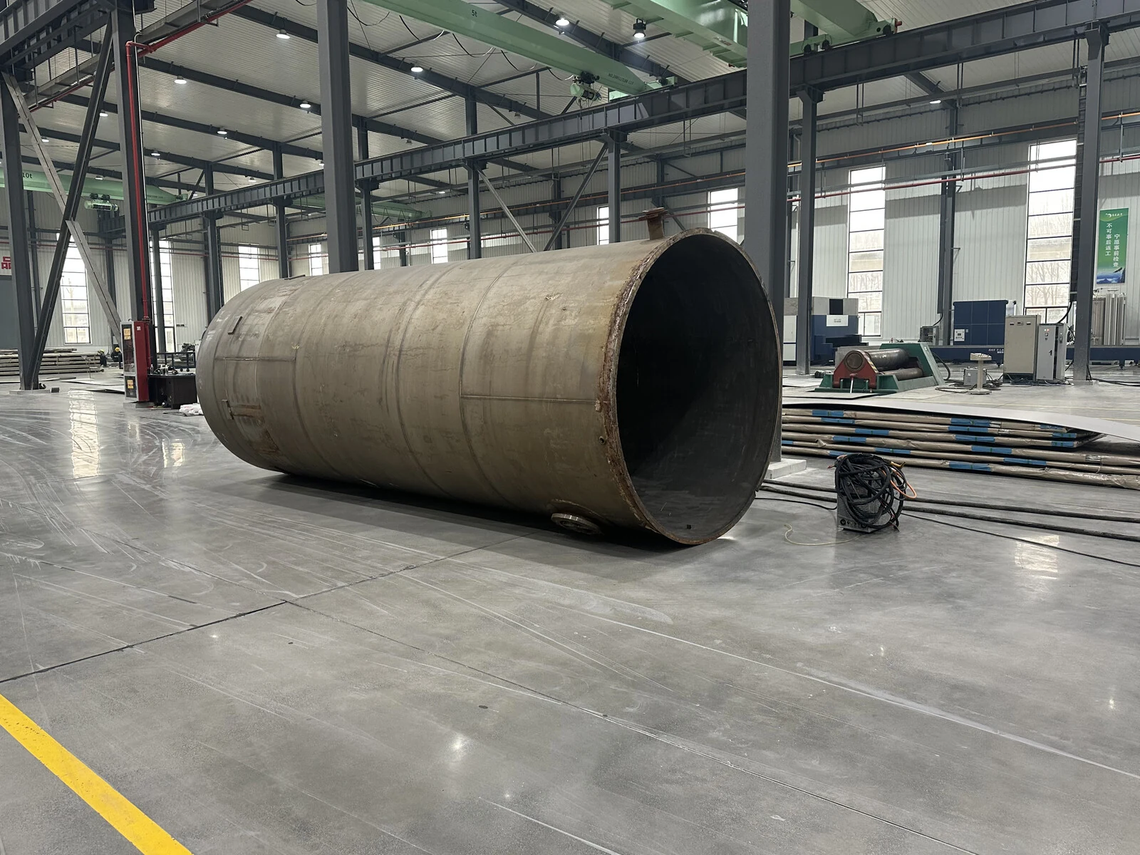 Large titanium pressure-vessel shell in a workshop, showing the pressure boundary where forming, welding, inspection and release records must meet.