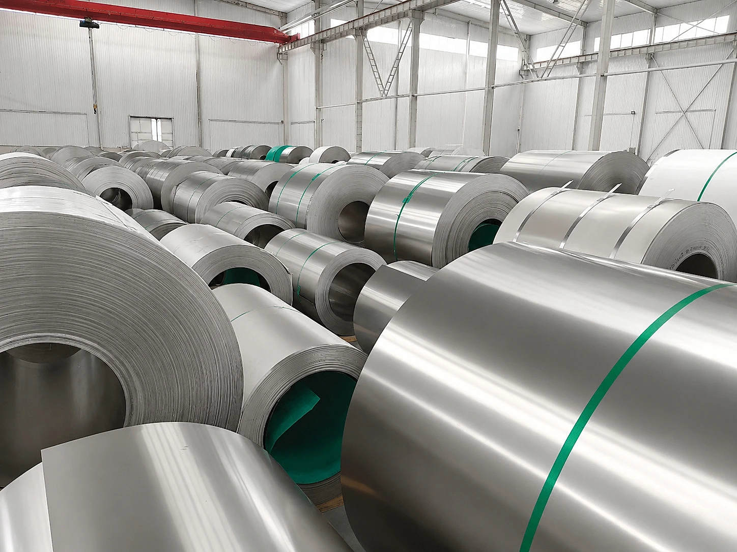 Titan-Blechcoils in einem Lager, die zeigen, warum strategische Mineralversorgung weiter mit Produktform, Zuteilung und Freigabenachweisen verbunden werden muss.