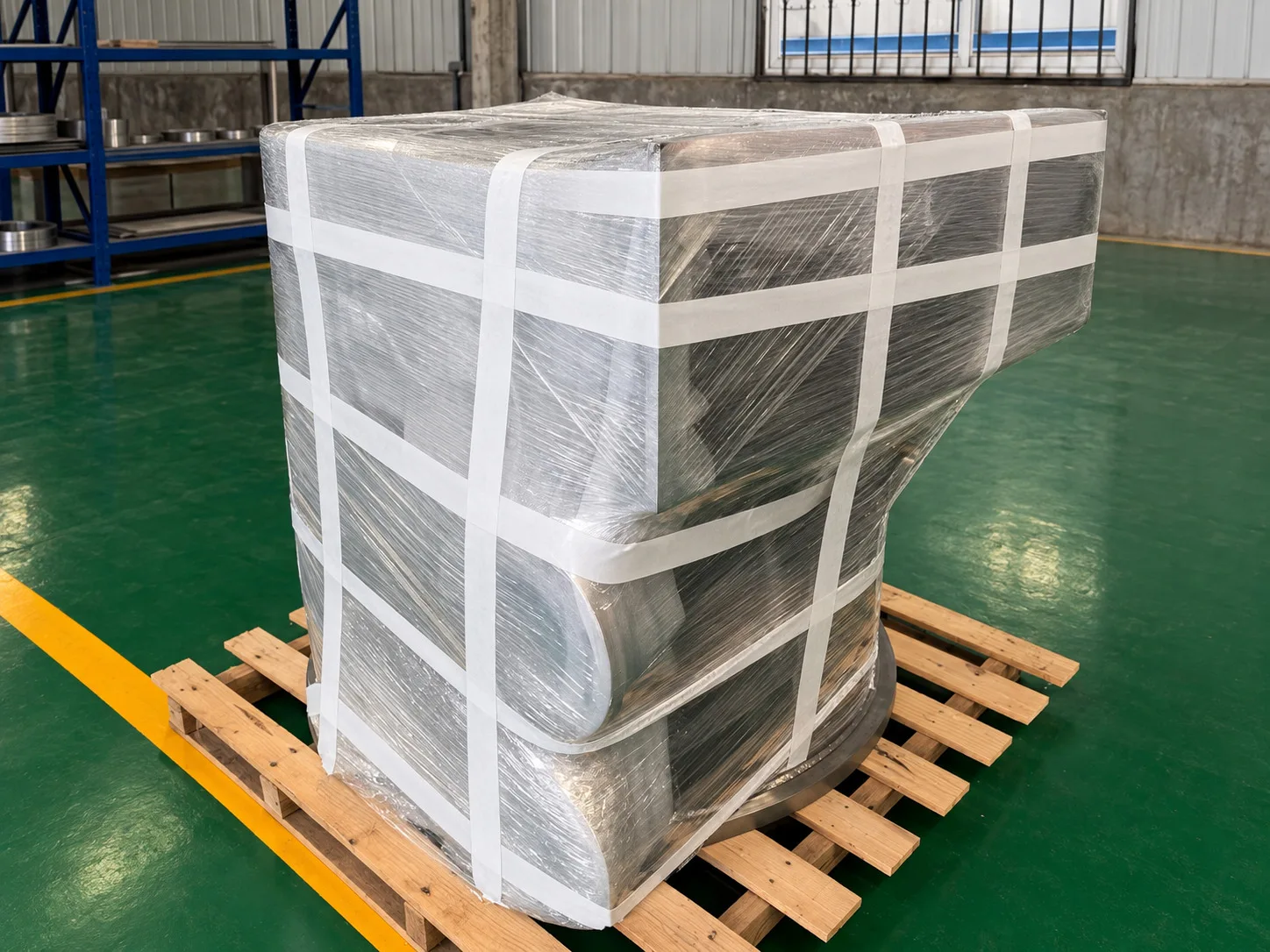 Wrapped fabricated metal assembly secured on a wooden pallet